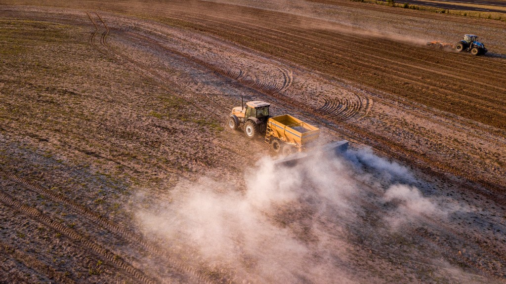 Tractor spreading rock dust on an agricultural field